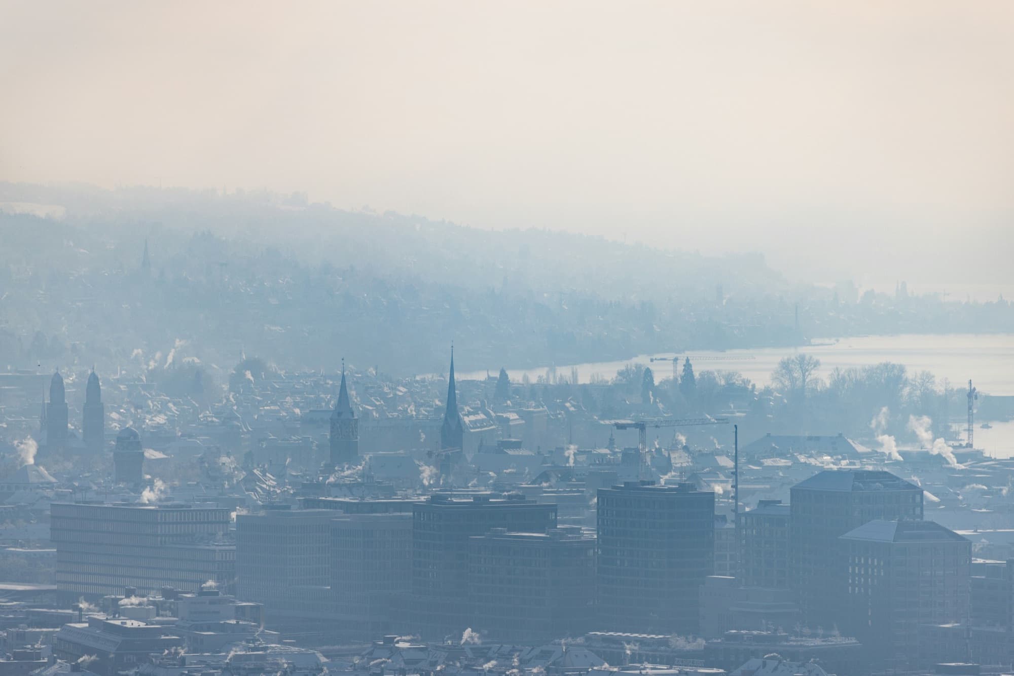 Zürich im Winterdunst von oben, Kirchtürme und der See dahinter